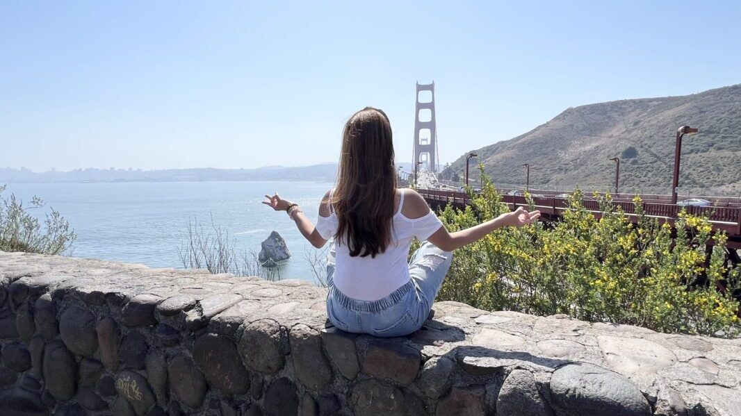 A woman meditates near the golden Gate Bridge in San Francisco 